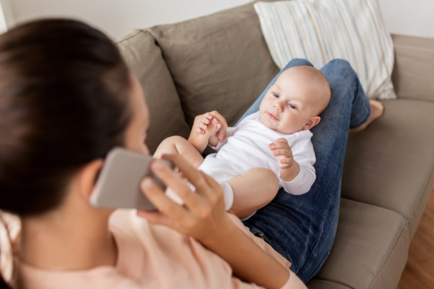 Baby. Mamma. Sitter på fanget. Telefon