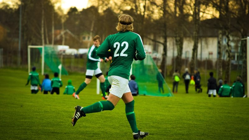 Fotballspiller, fotballdrakt, fotballbane, mål, løper