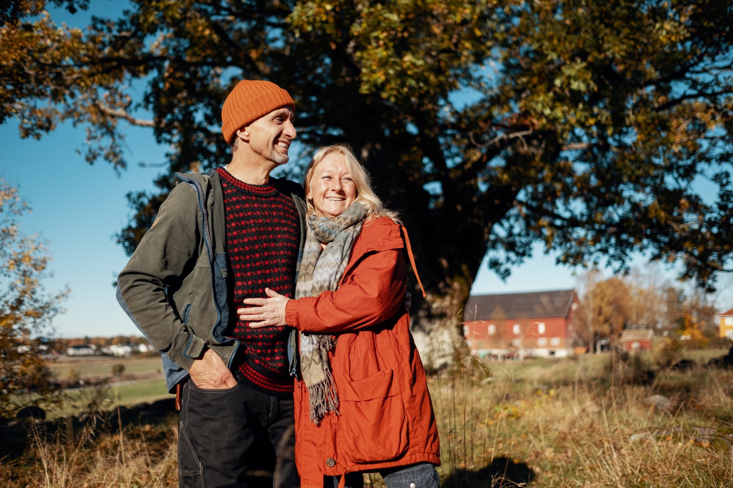 Et middelaldrende par står foran en norsk bondegård