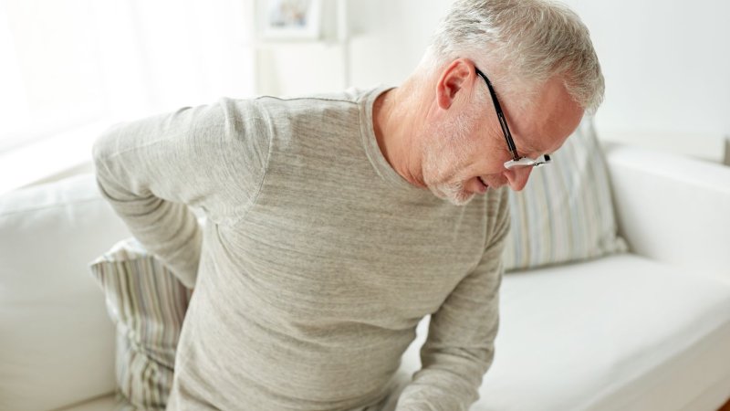 Bildet viser en eldre mann med ryggsmerter