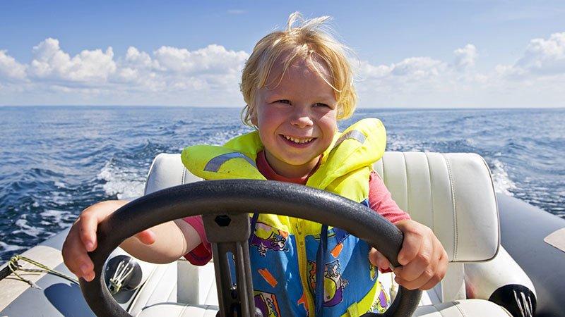 gutt som styrer båt