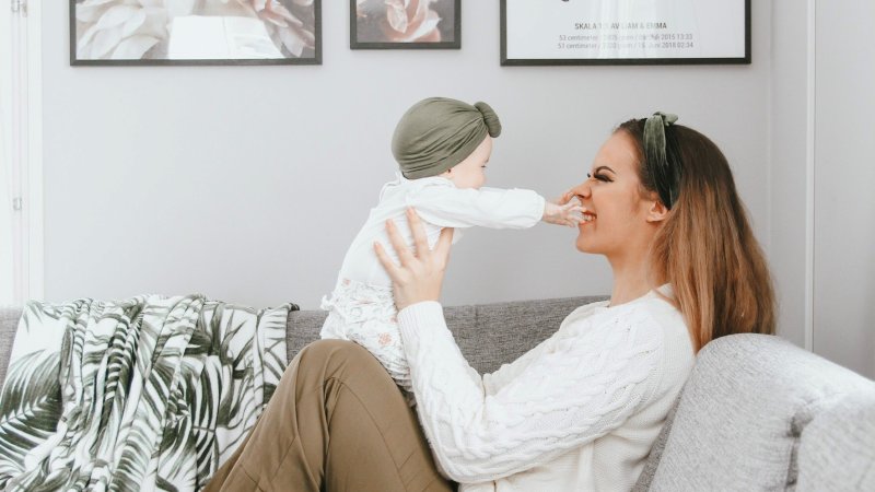 Bildet viser influenser Sara Emilie Tandberg, som sitter i sofaen sammen med babyen sin.