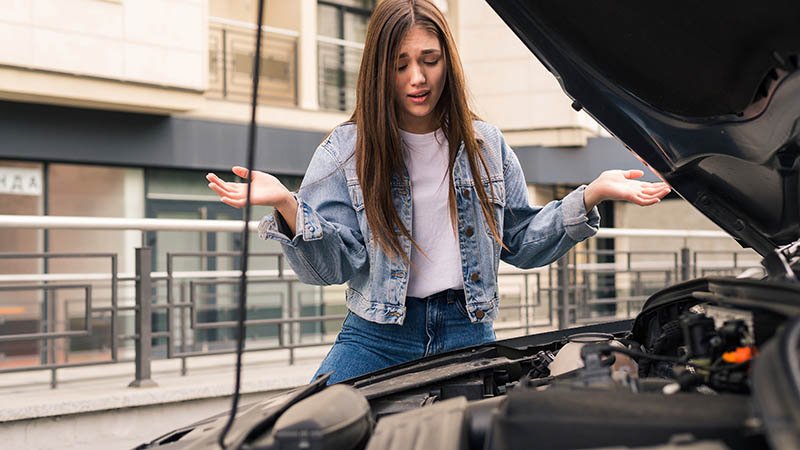 Young woman. Happy. In car with key.