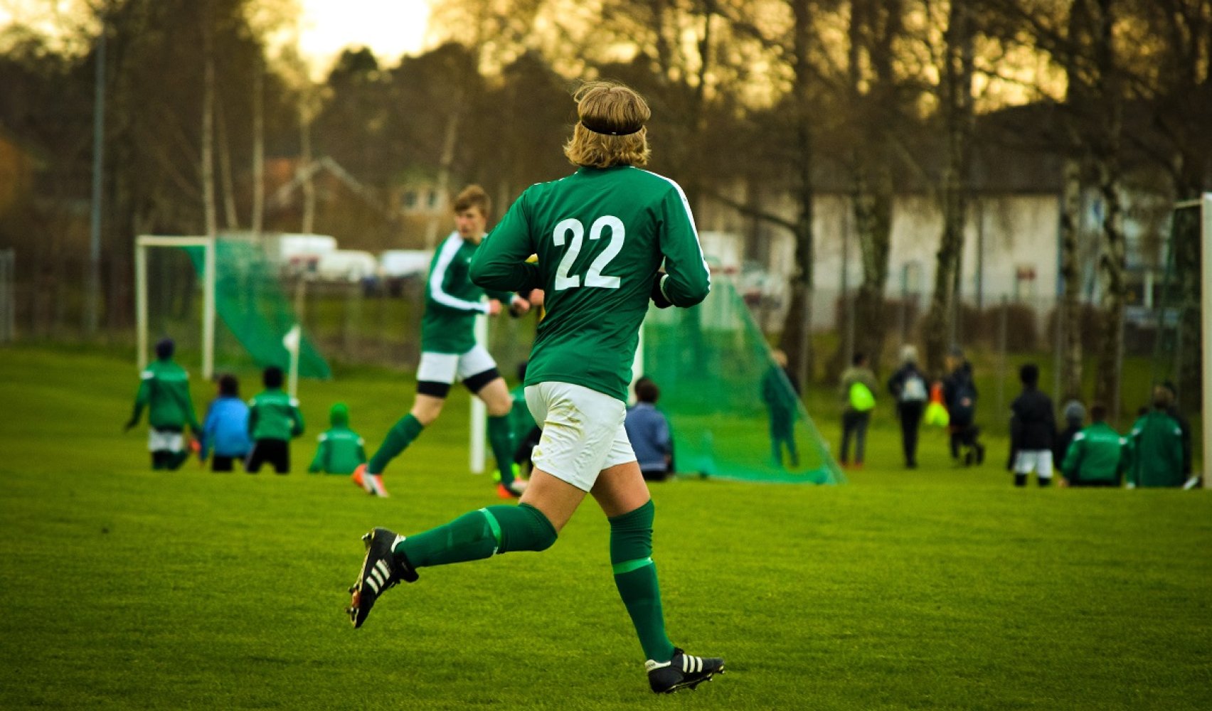 Fotballspiller, fotballdrakt, fotballbane, mål, løper