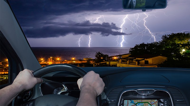 Kjørende bil i tordenvær.