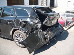 Sort bil, ødelagt bakdel, parkeringsplass