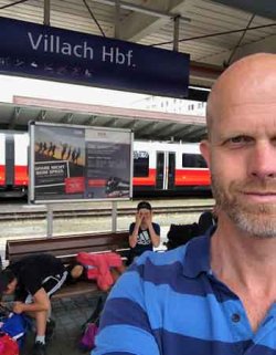 Hallgeir Kvadsheim på en togstasjon i Østerrike. Bak: trette familie-medlemmer. Foto: Privat