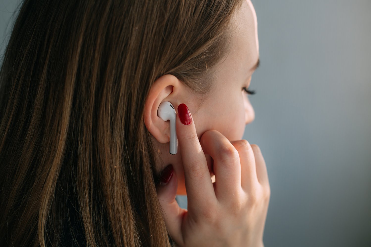 En ung person lytter til trådløse hodetelefoner