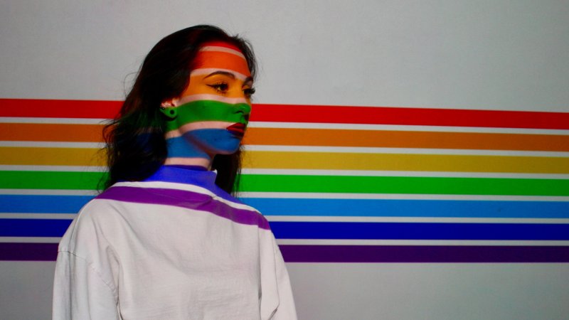 Ung jente med regnbuefarger i ansiktet