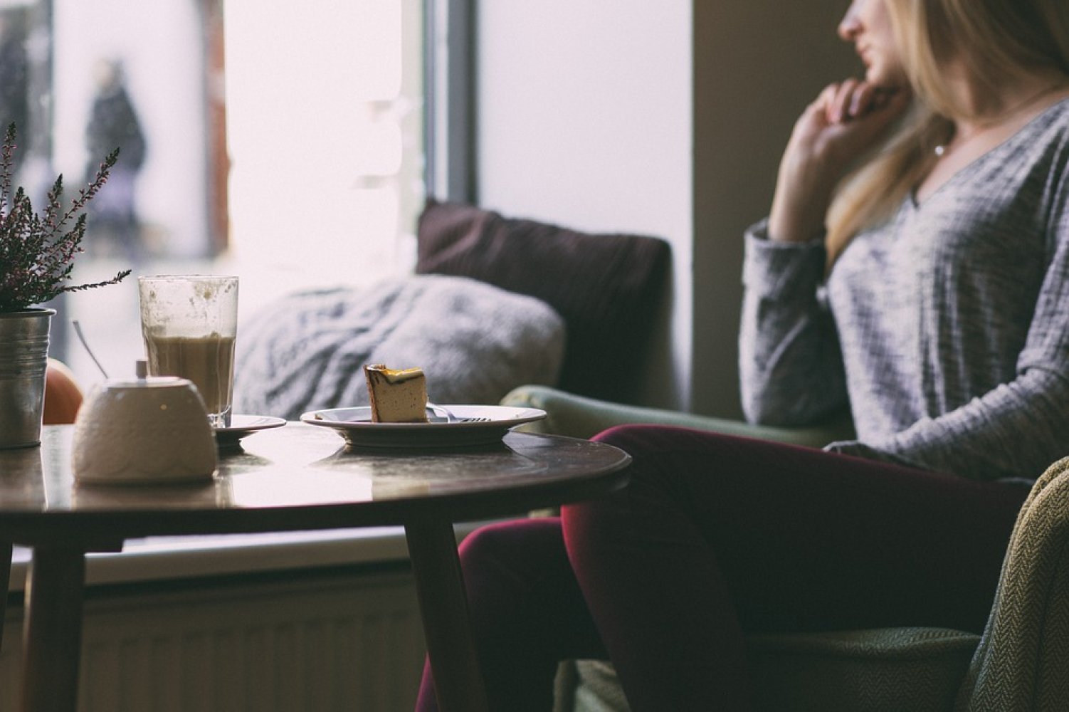 Bildet viser en betenkt kvinne på cafe