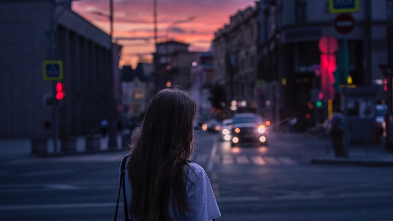 En jente står alene foran et veikryss
