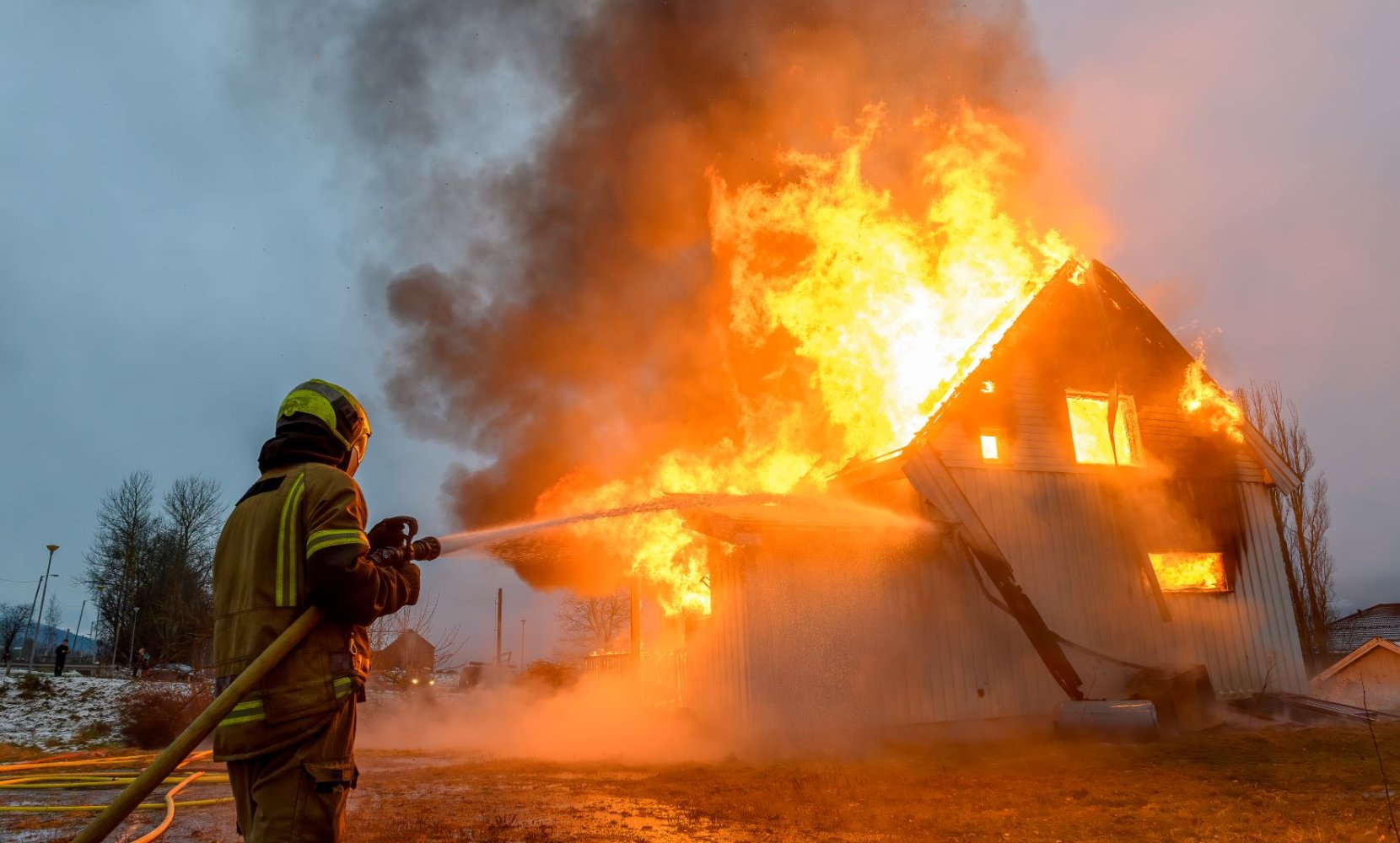 Bildet viser en brannmann som slukker en landbruksbrann