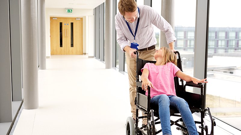 Barn i rullestol på sykehus.