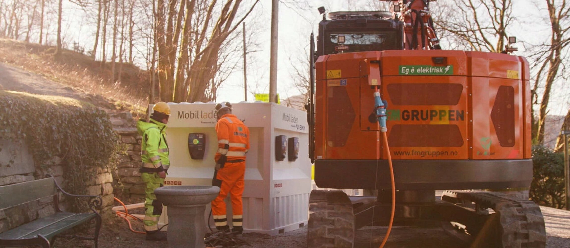 Byggeplass med elektriske anleggsmaskiner og kjøretøy.