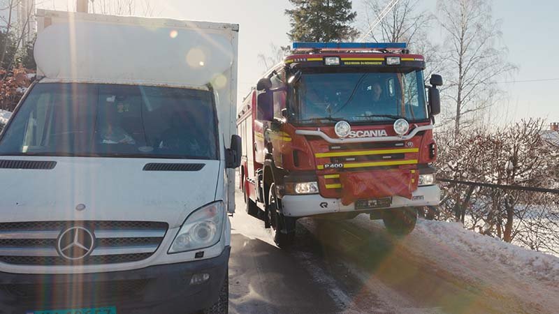 Brannbil som kjører forbi en feilparkert lastebil.