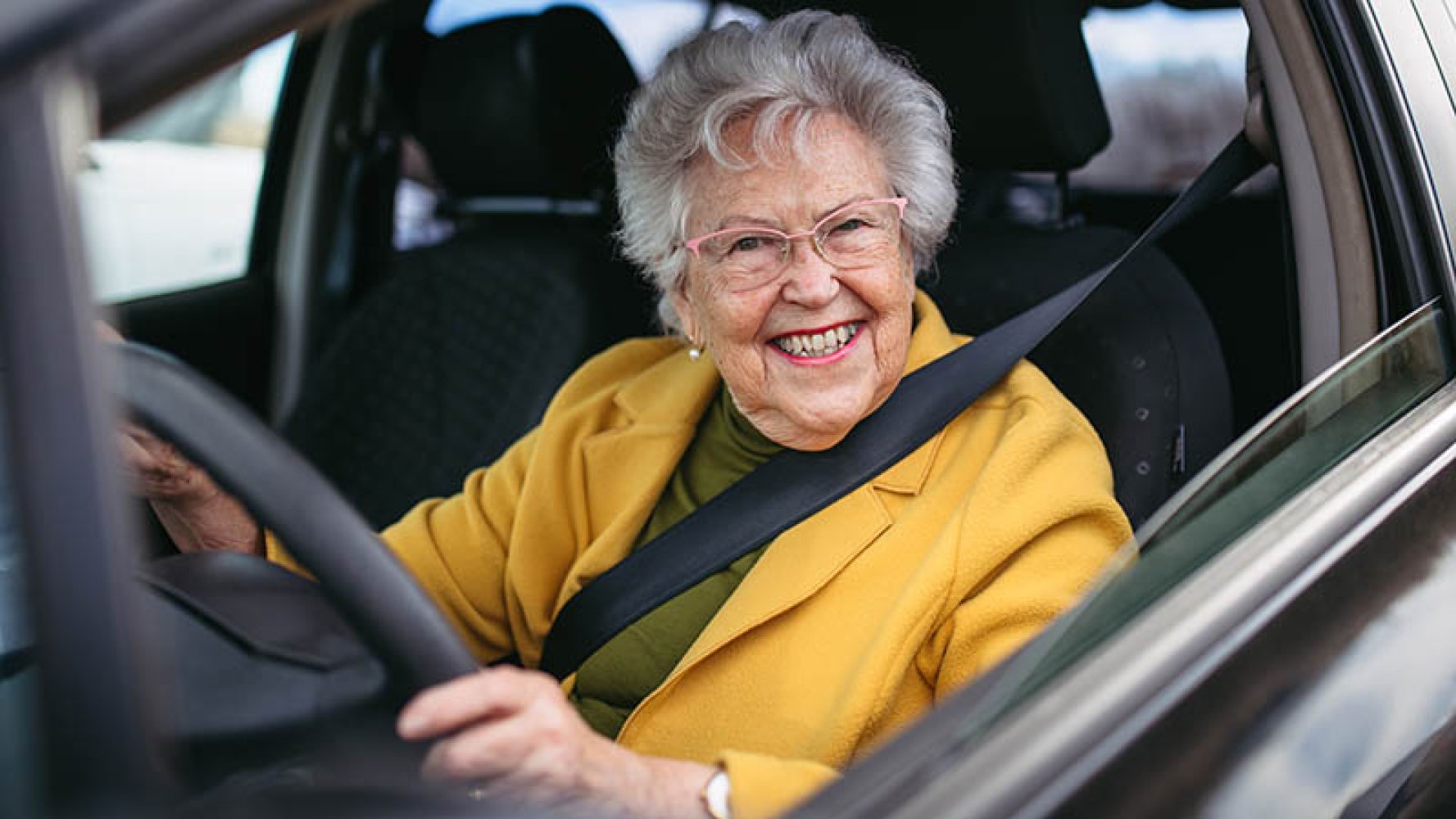 Eldre dame bak rattet i en bil