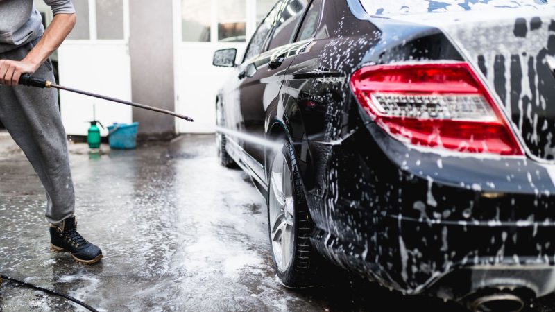Bildet viser en mann som vasker bilen med høytrykkspyler