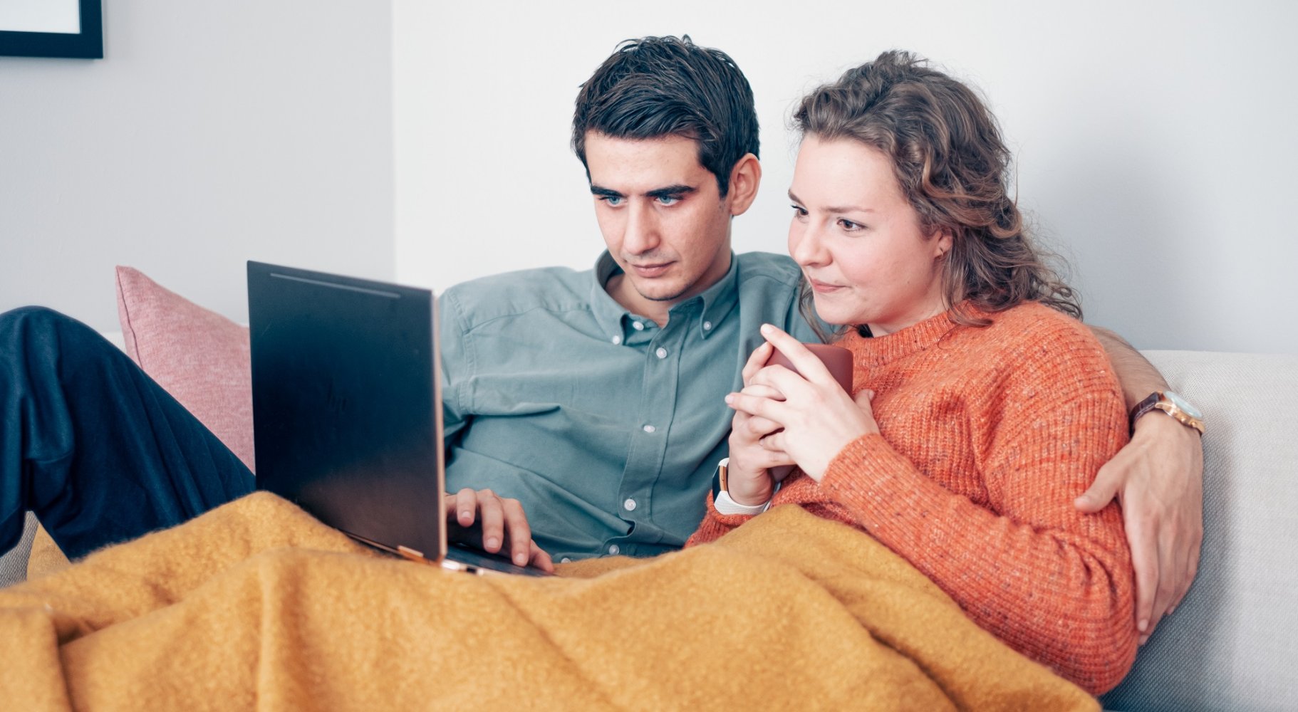 ungt par med laptop i sofaen