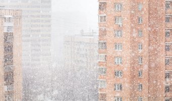 Boligblokker. Snø i lufta.