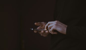 Bilde av mobiltelefon i hendene til en mann