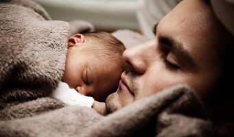 Mann med baby i sengen