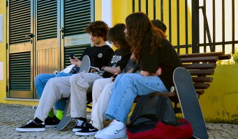 Ungdommer sitter på benk.