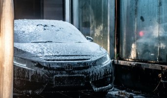 Bronsefarget Land Rover med såpeskum i vaskehall.
