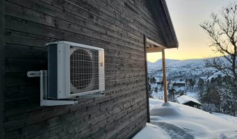 Varmepumpe på yttervegg på en hytte.