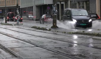 Biler kjører gjennom vanndammer i Oslo
