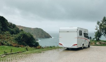 En bobil står parkert ved en strand.
