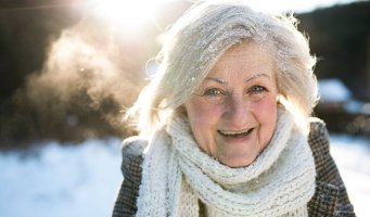 Eldre dame i vinterlandskap.