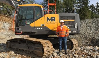 Svein-Erik Ryen står foran en gravemaskin.
