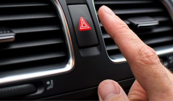 Finger som trykker på varselblink-knappen.