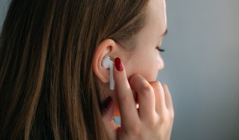 En ung person lytter til trådløse hodetelefoner