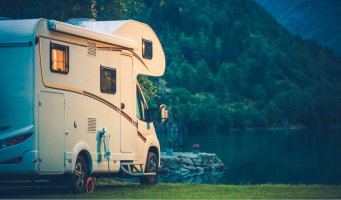 Campingvogn. Et vann i bakgrunnen.