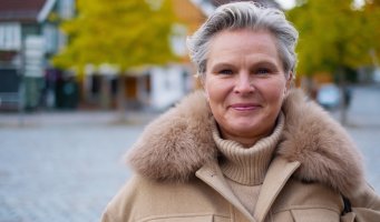 Bilde av ansatt som smiler utendørs