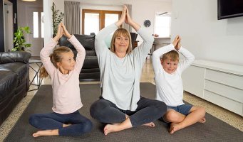 Mot og to barn som prøver yoga.