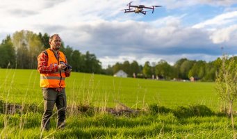 Bonde med drone i åker.