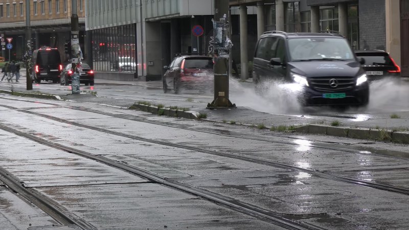 Biler kjører gjennom vanndammer i Oslo